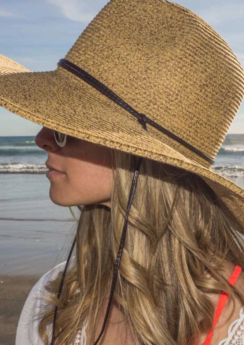 A woman wearing a Sungrubbies hat at the beach.