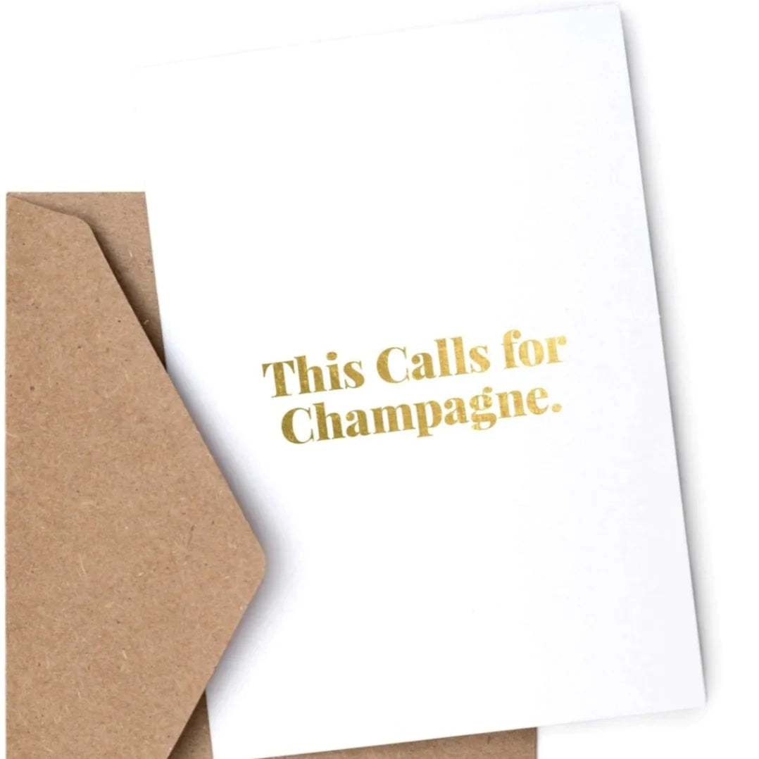 A card with the phrase "This Calls for Champagne" in gold across the front.