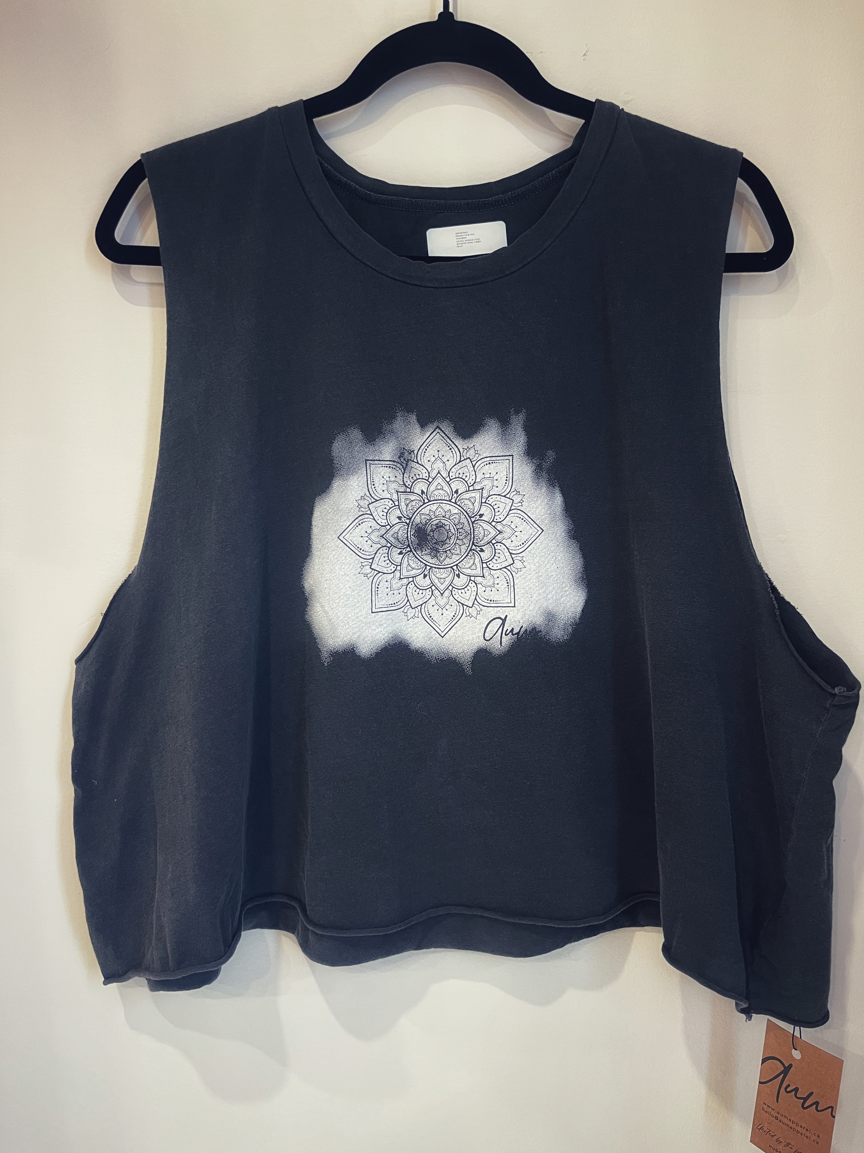 A black tank top with an etched mandala and Aum logo design in white.