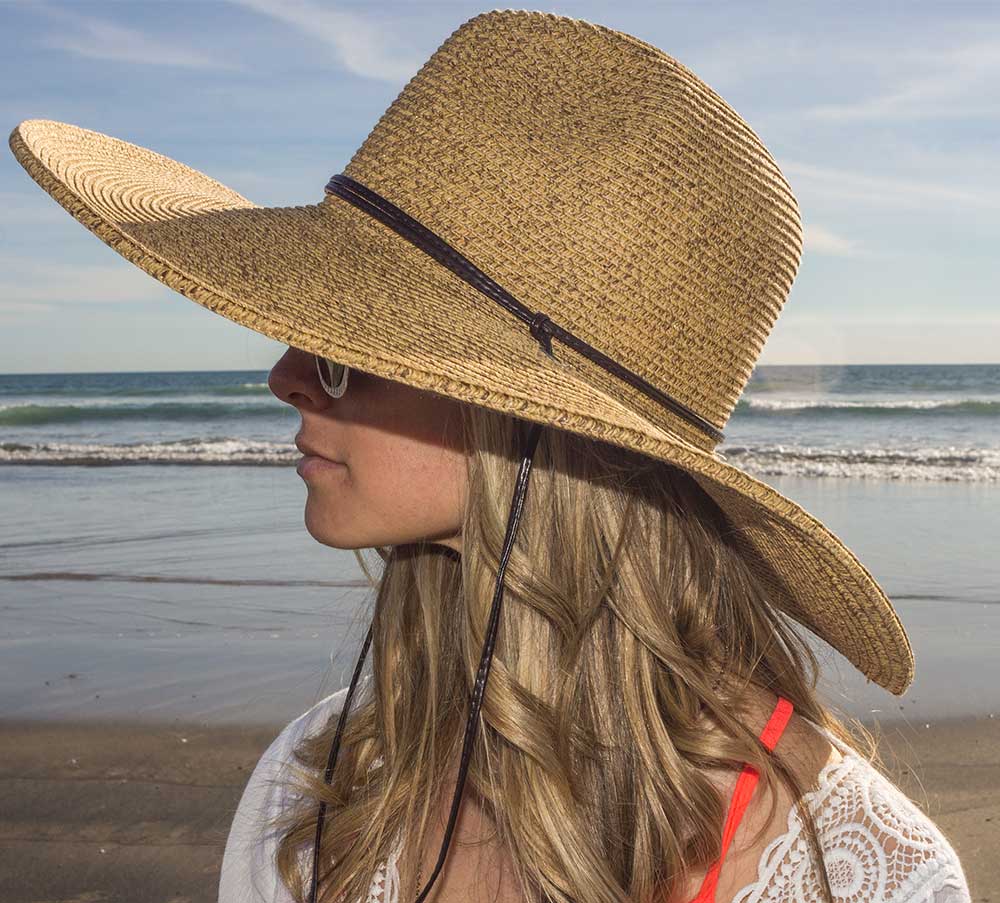 A woman on a beach wearing the Sungrubbies El Ranchero Summer Hat.